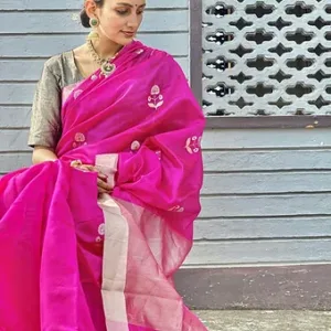 Model wearing a magenta pure silk Chanderi saree featuring delicate white floral butta motifs and a soft silver zari border, paired with a contrasting blouse and traditional jewelry
